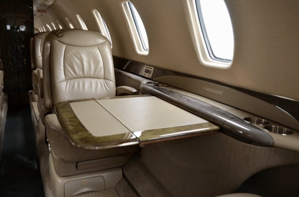 View of the interior cabin with leather seats and a table.
