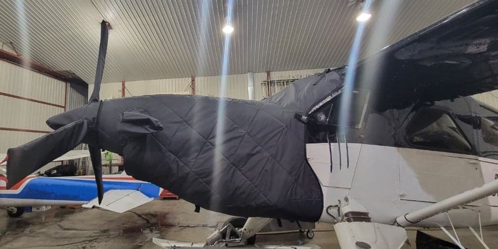 Seaplane with a black engine cover in a hangar.