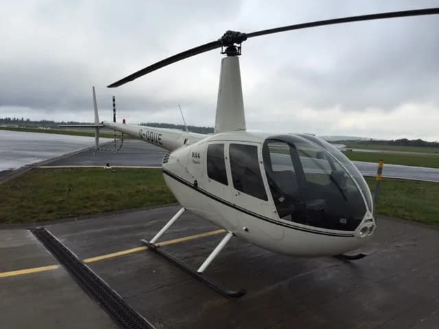 Robinson R44 Raven on the tarmac with a white paint scheme.