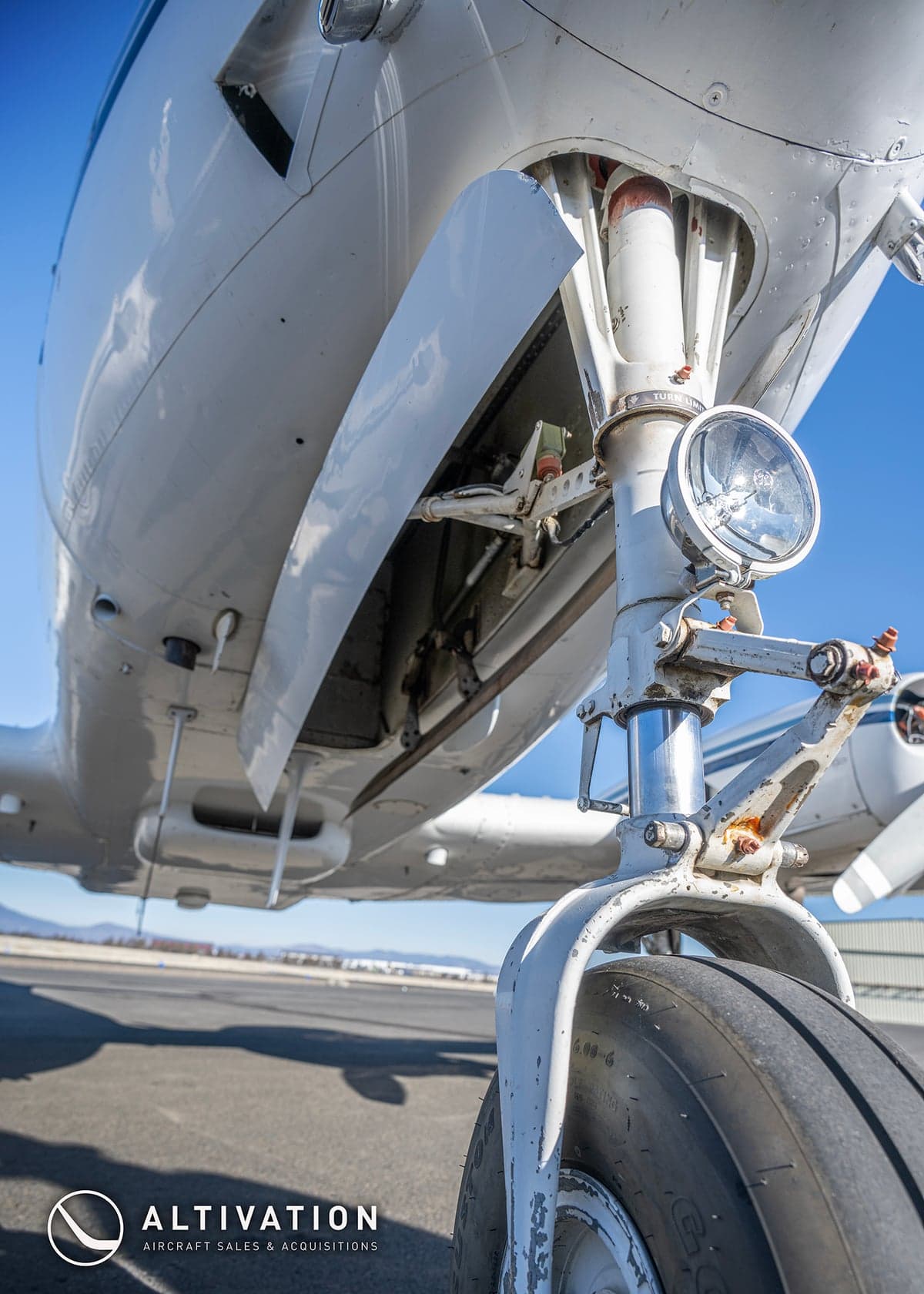 Front view of a white and blue twin-engine aircraft, registration N7719Q, on the tarmac.