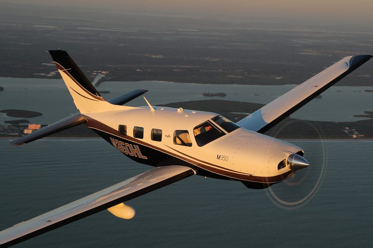 Close up aerial view of a Piper M350 over the ocean.