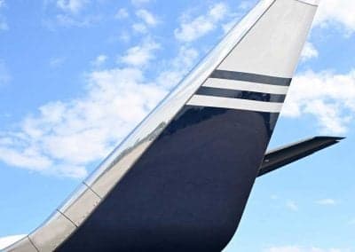 Tail section of a private jet with blue and white stripes.