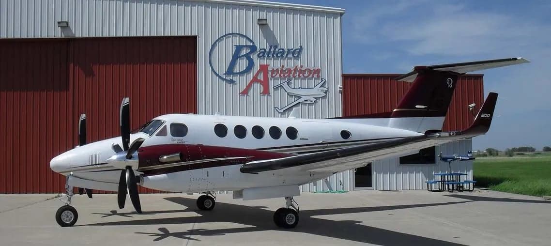 A Beechcraft King Air 300 parked in front of a hangar.