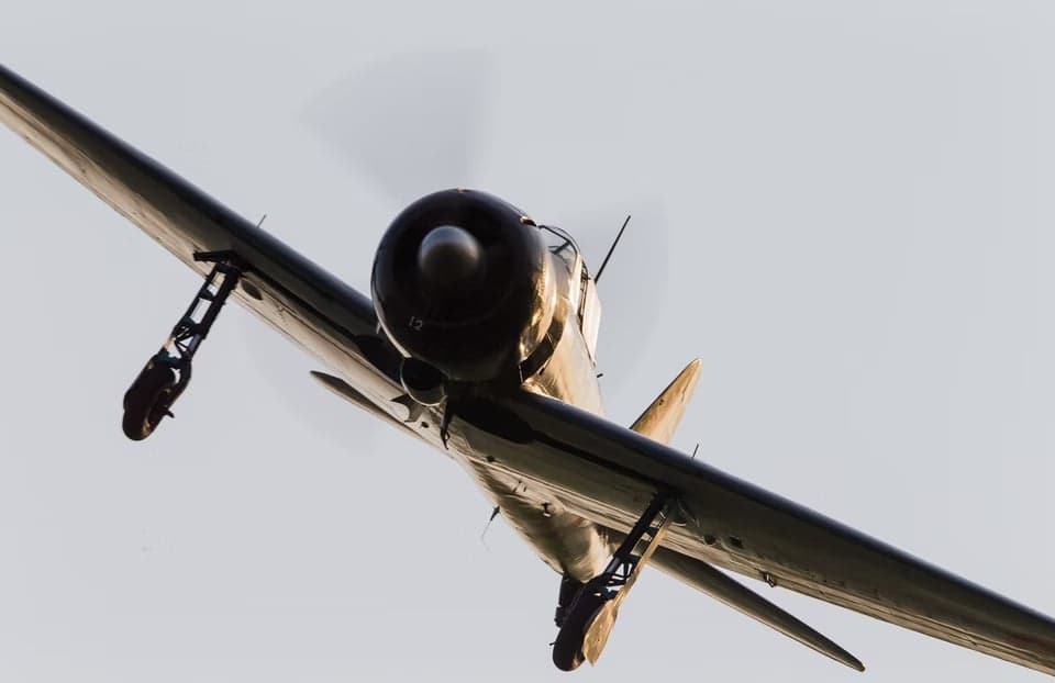 A Mitsubishi A6M Zero flying in the sky.
