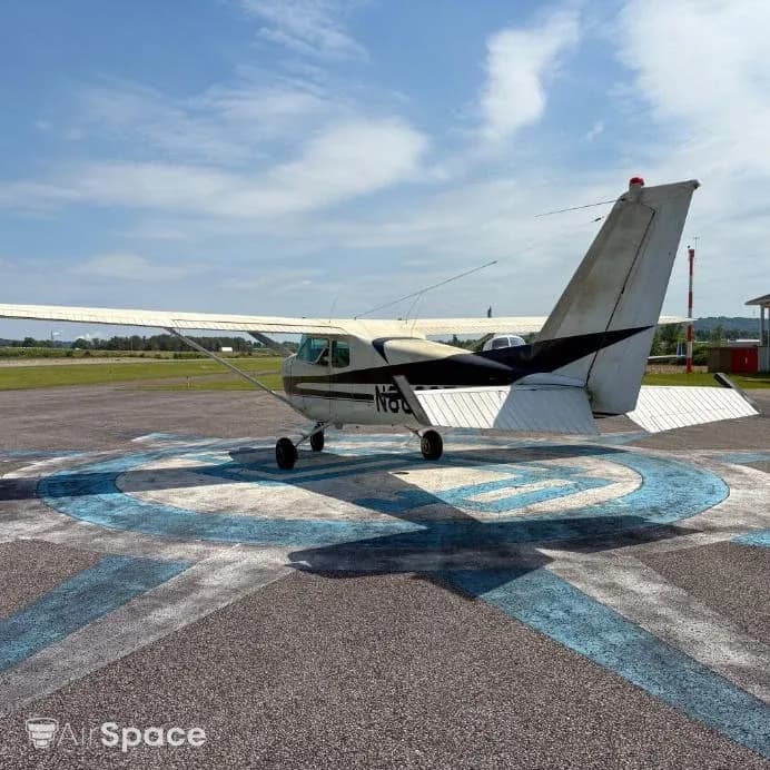 Rear-left view of a white and black Cessna 172 N8032T parked on an airfield.