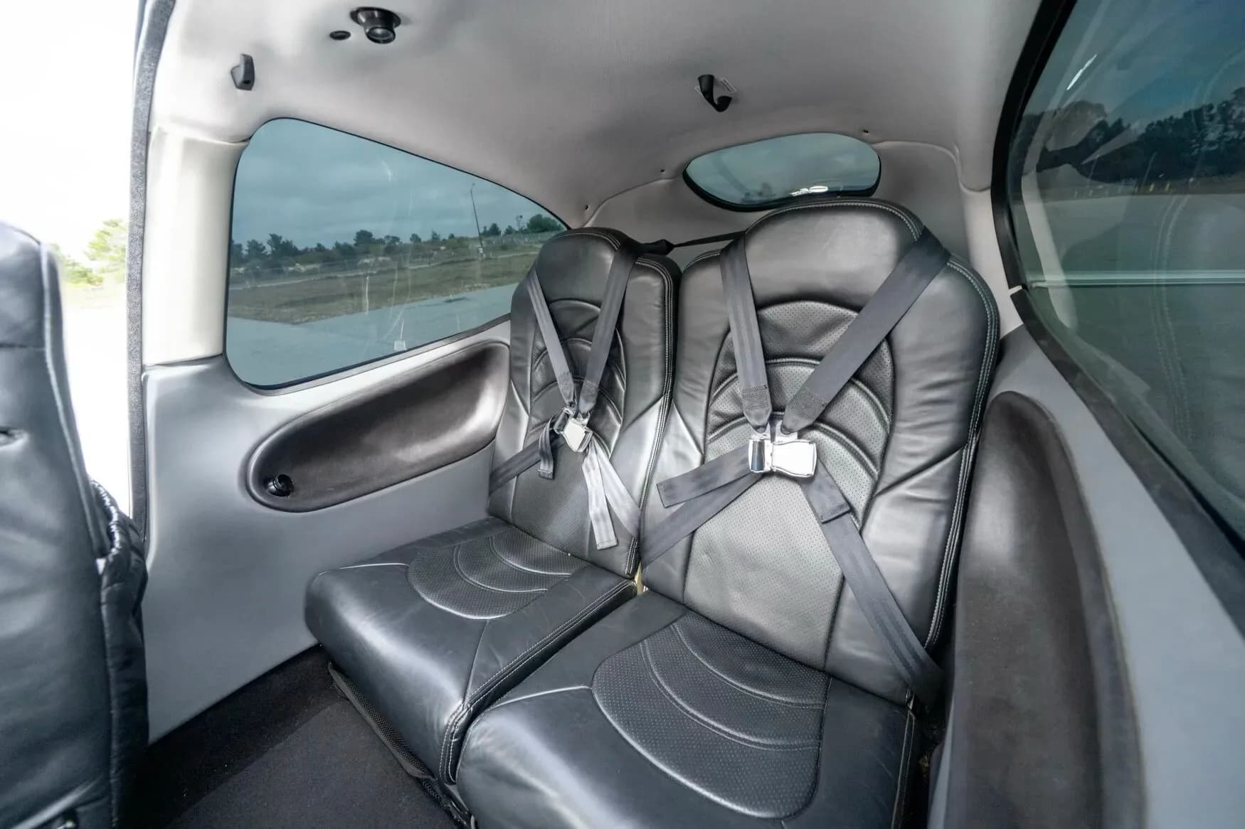 The black leather rear cabin seats with seatbelts in the Cirrus SR22 G3 Turbo aircraft.