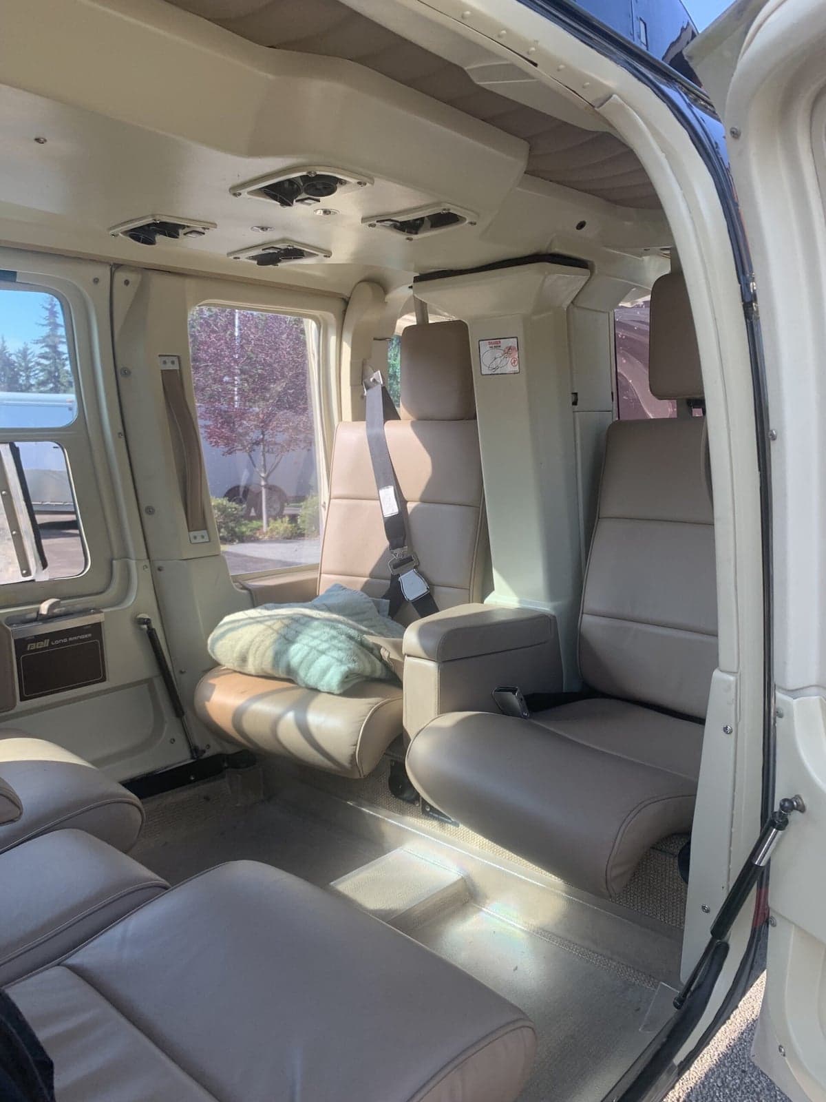 Interior view of the Bell 407 helicopter cabin with beige leather seats.