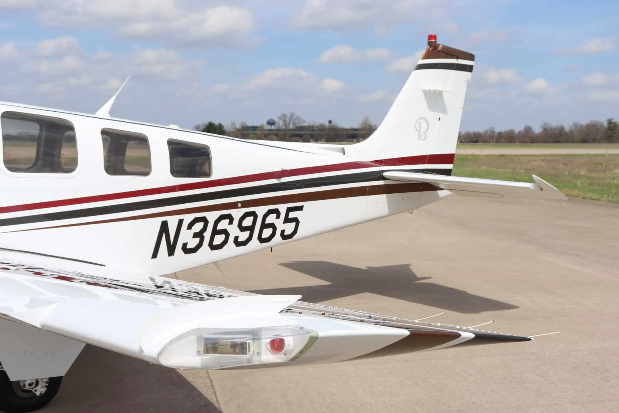 A close-up of the tail section of the Beechcraft Bonanza G36, showing the N36965 registration and a 'B' logo on the tail.