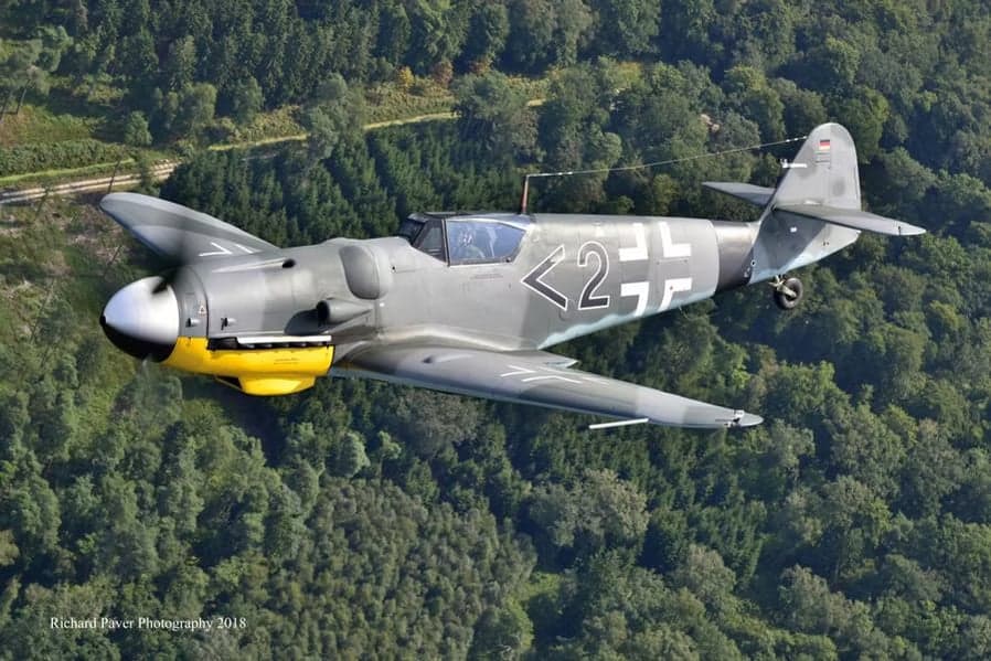 A Messerschmitt Bf 109 flying over a forest.
