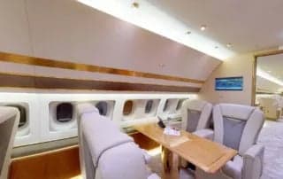 A view of the aircraft's interior, featuring leather seats and a wooden table.