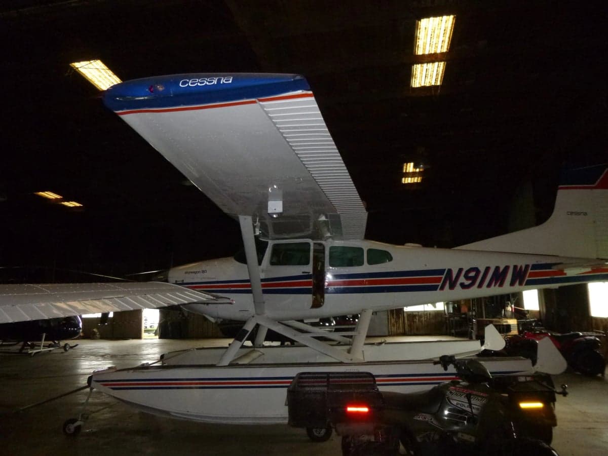 Cessna Skywagon 185 floatplane with registration N91MW in a hangar.