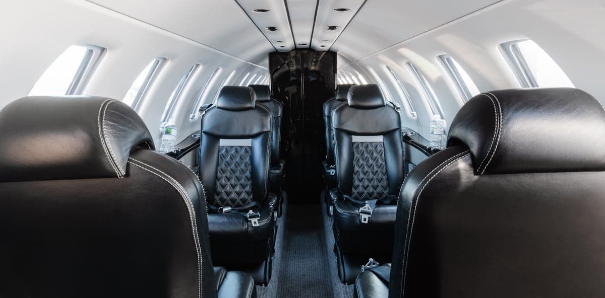 View of the aircraft's interior cabin with black leather seats.