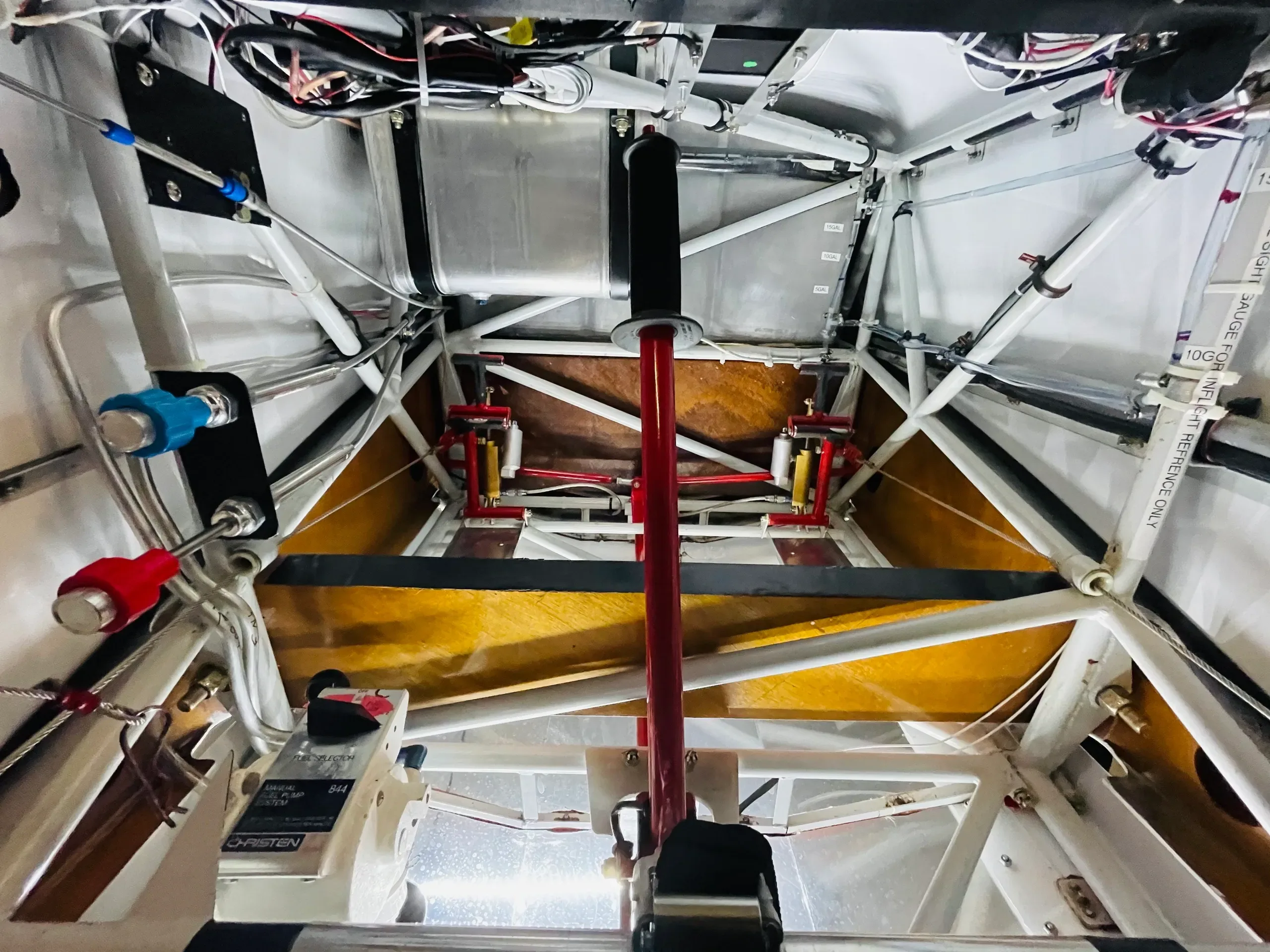 A view of the internal structure and control linkages of an aircraft, with a red control stick visible.