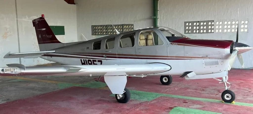 Side view of a Beechcraft Bonanza in a hangar.