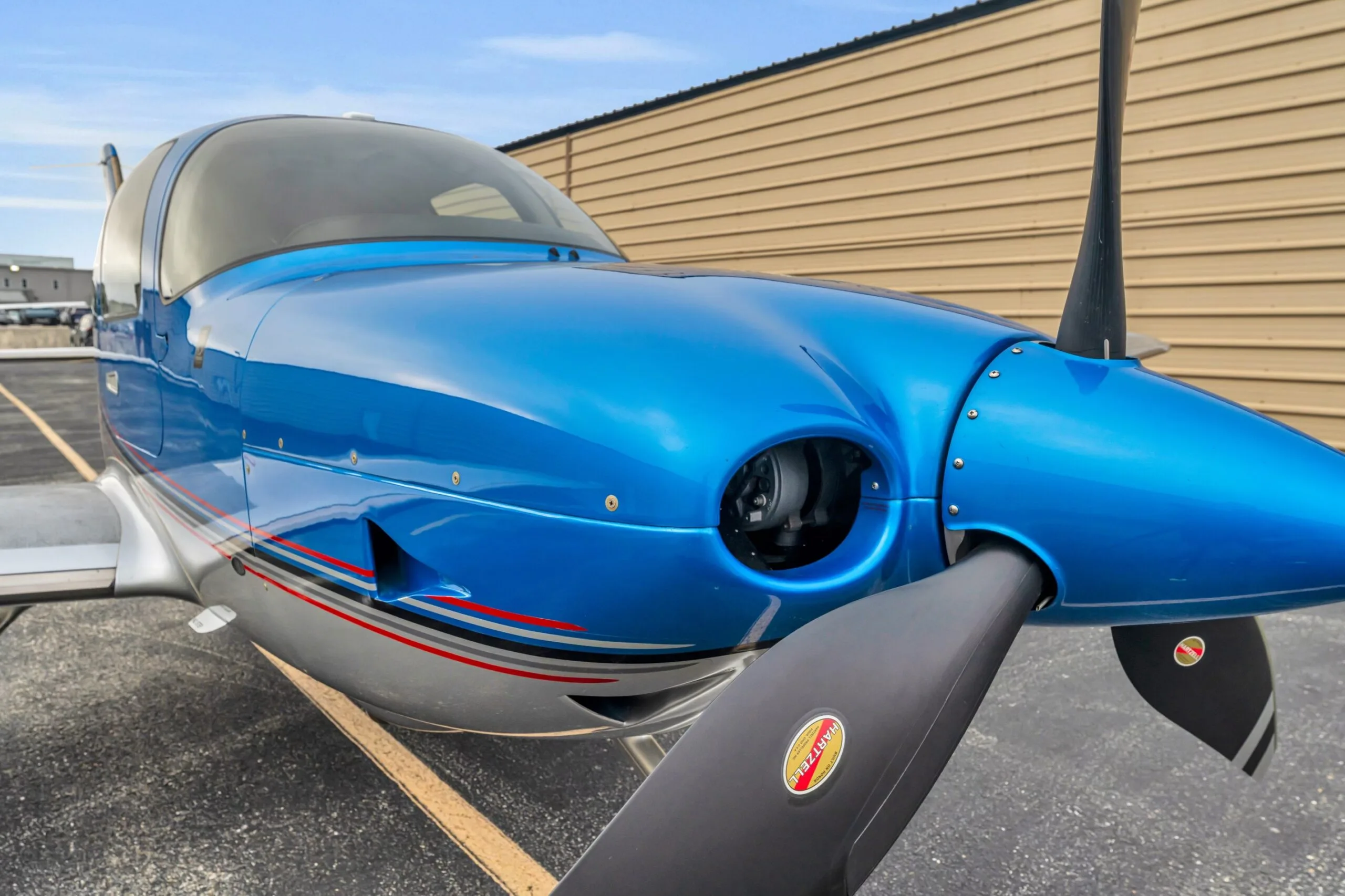 A detailed close-up of the propeller and engine cowling of the blue Cirrus SR22T GTS aircraft N66TM.