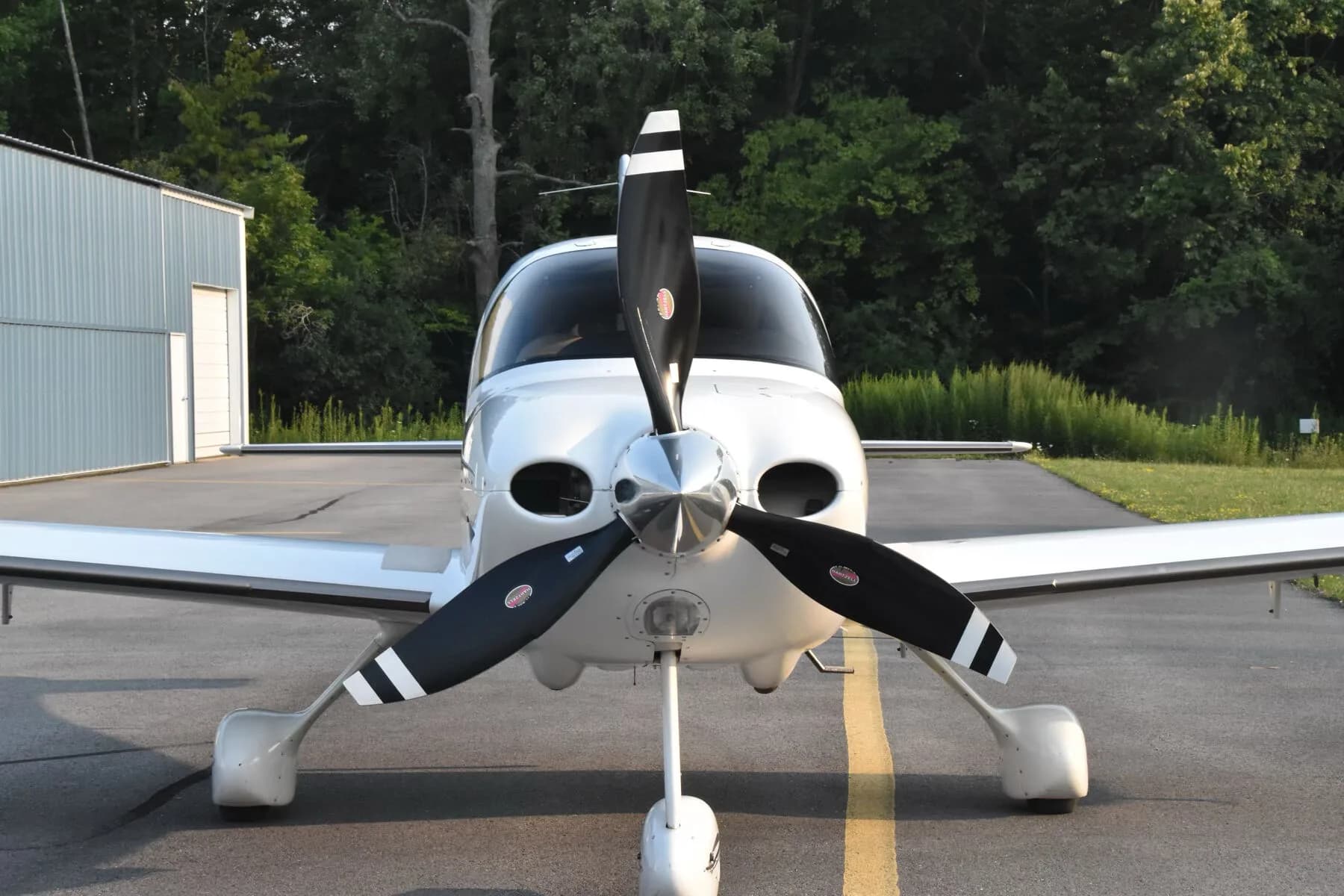 A close-up front view of the white Cirrus SR22T aircraft (N685SR) showing its propeller and landing gear.