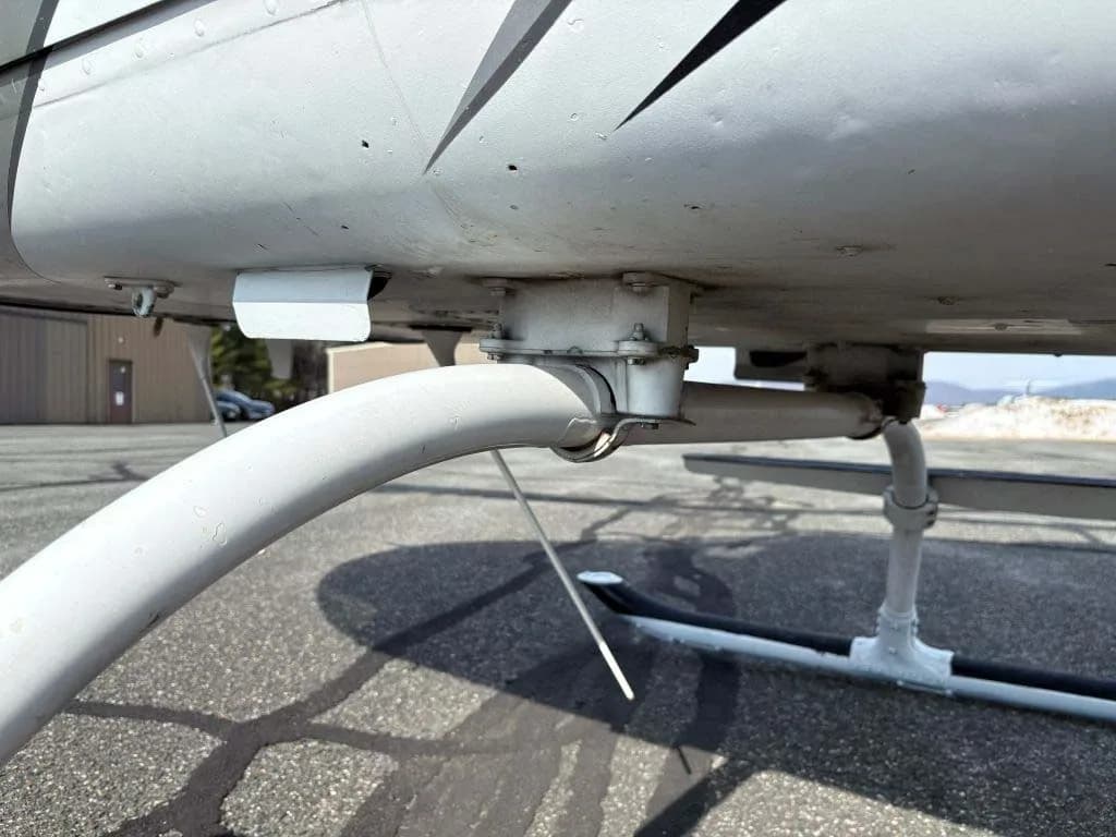 A close-up view of the white skid landing gear and underside of a helicopter.