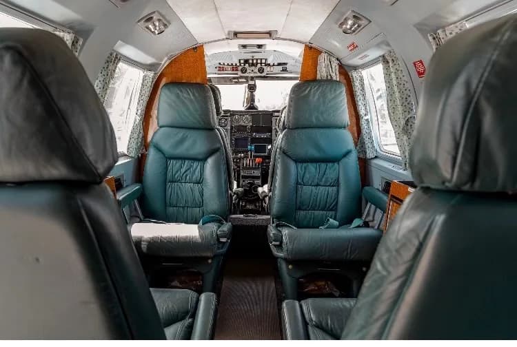 View of the aircraft interior with leather seats and wood trim.