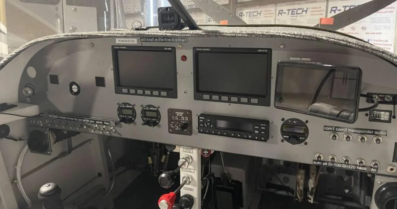 Close-up view of the aircraft's instrument panel with two large digital displays and various controls.