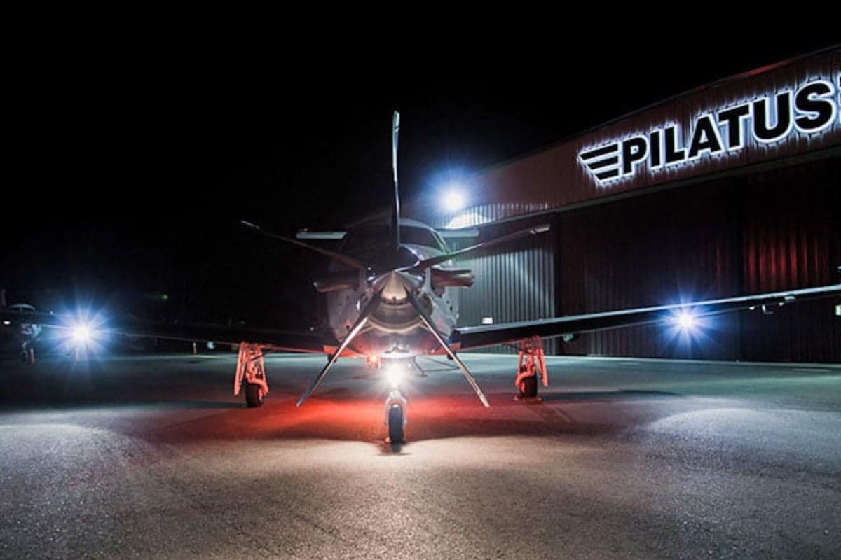 Front view of a Pilatus aircraft on the tarmac at night.