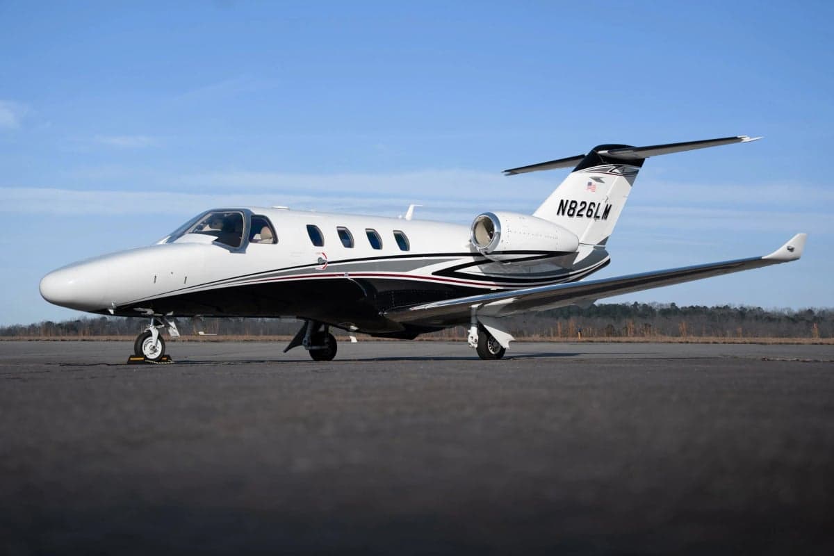 A Cessna Citation CJ3 aircraft is parked on the tarmac, showing its tail number N826LM.