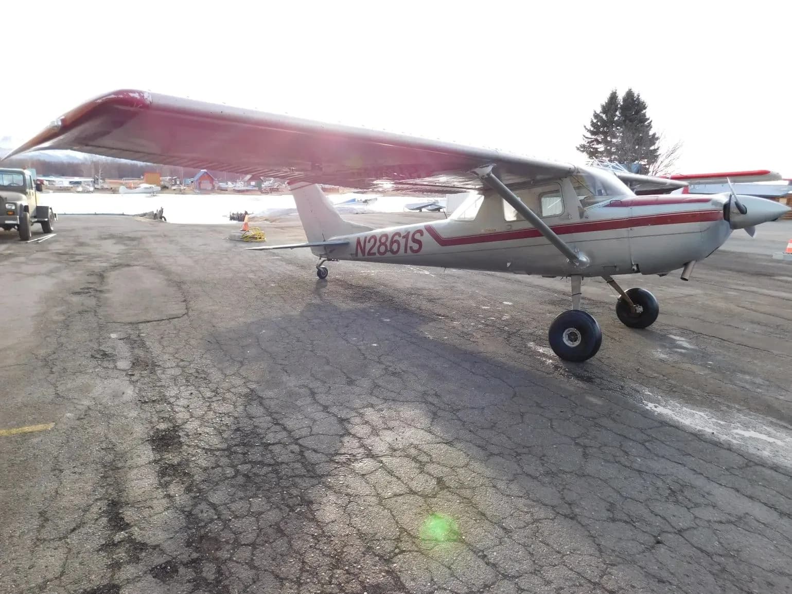 A silver and red single-engine propeller aircraft (N2861S) parked on a tarmac, viewed from the front-right.