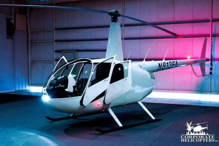 Robinson R44 helicopter N813FA in a hangar with open doors.