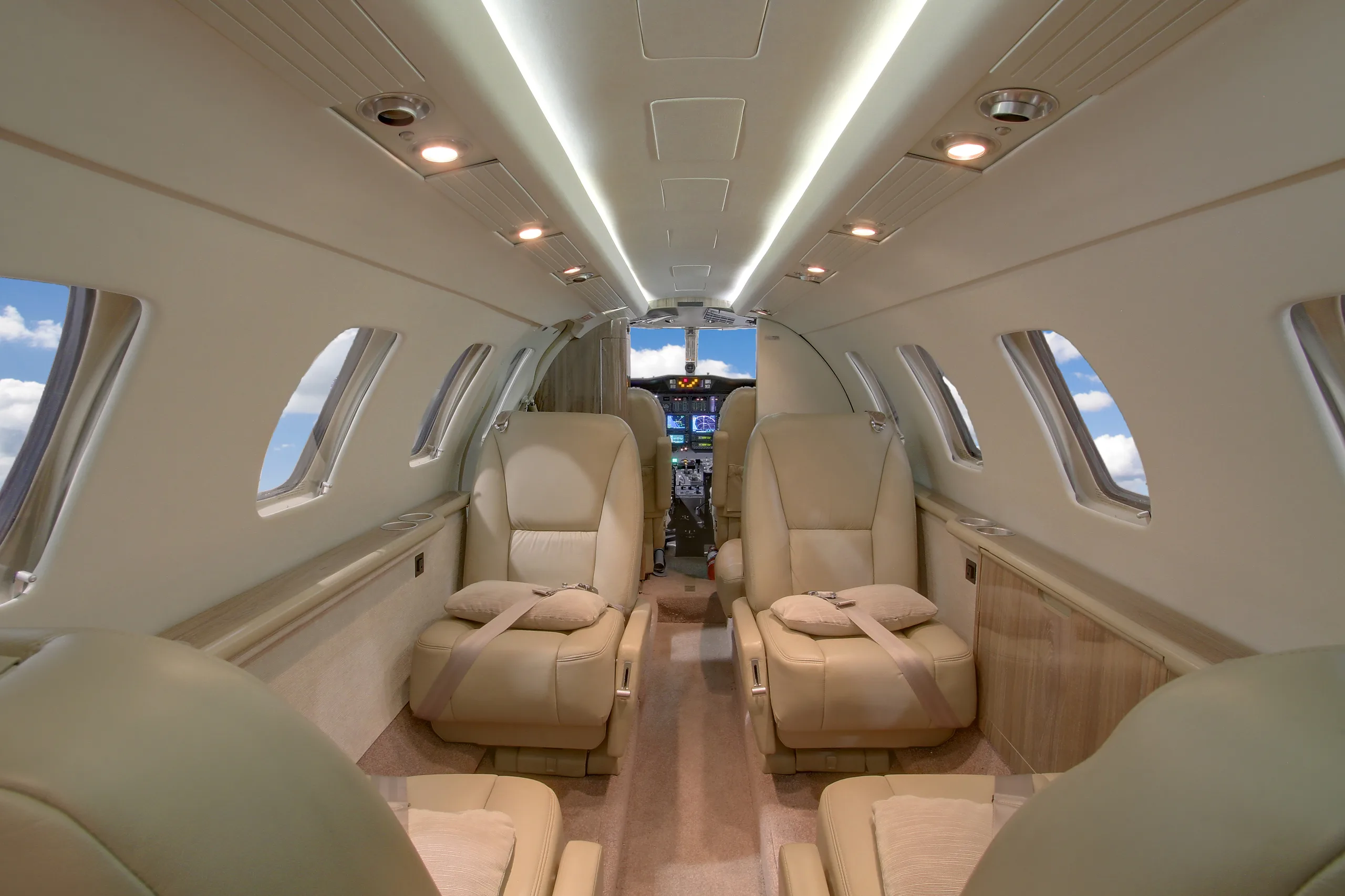 The interior of a Cessna Citation CJ3 features leather seats and a view of the cockpit.