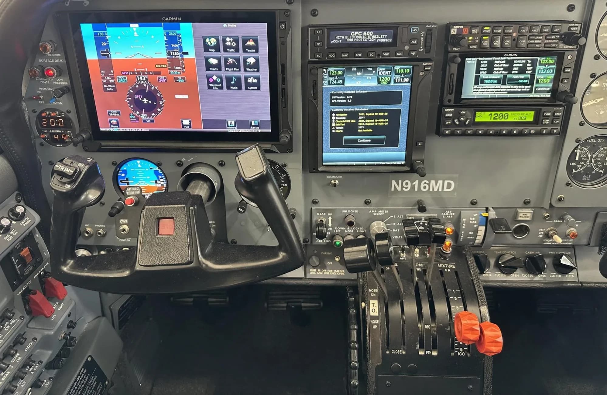 A close-up of the N916MD aircraft's cockpit instrument panel with modern Garmin avionics and controls.