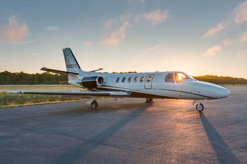 A side view of the N255TC aircraft on the tarmac at sunset.
