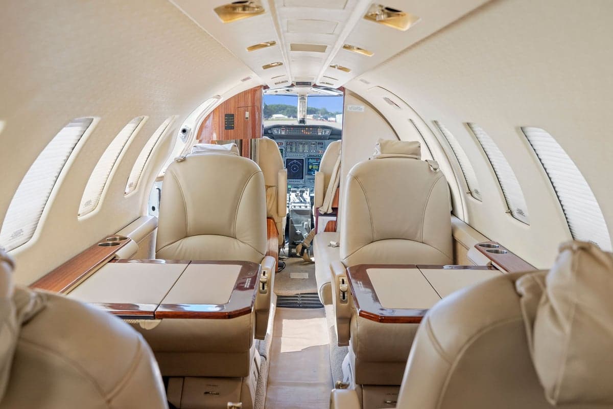 View of the aircraft interior showing leather seats and tables.