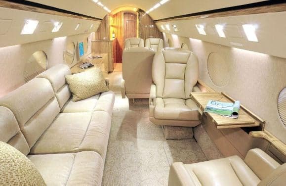 The interior of the aircraft features leather seats and a sofa.