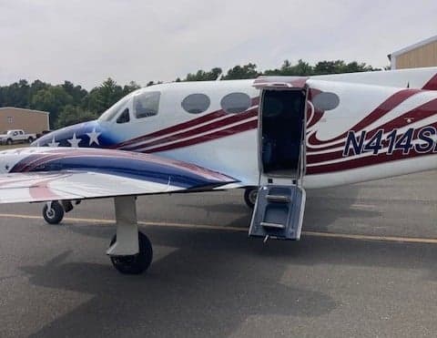 A Beechcraft King Air with an open door showing the registration number N414SD.
