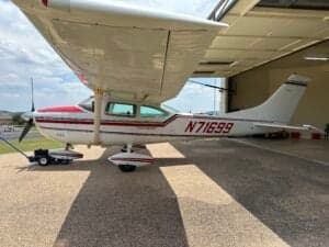 Side view of a Cessna 182 Skylane, registration N71699, parked on a paved surface with a tow bar attached.