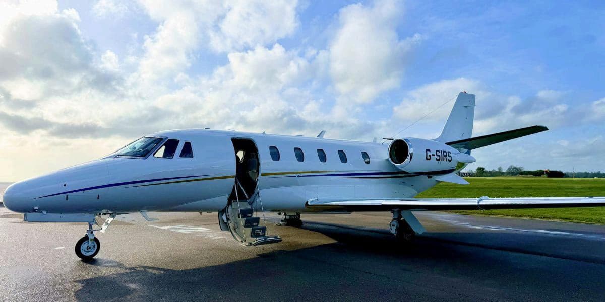 A Cessna Citation CJ2+ with an open door on the tarmac.