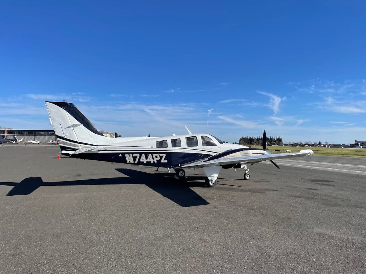 A Piper PA-31-350 Navajo Chieftain aircraft with a white and black paint scheme parked on the tarmac.