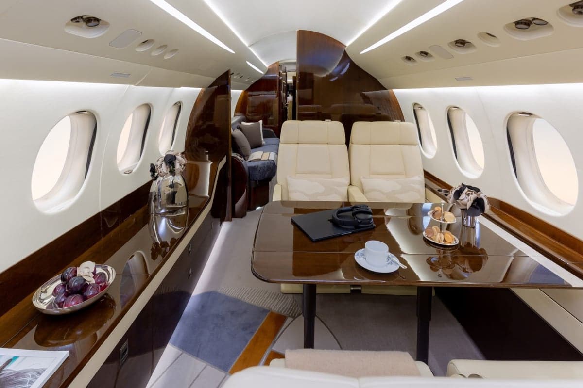 View of the aircraft interior with cream-colored seats and monitors.