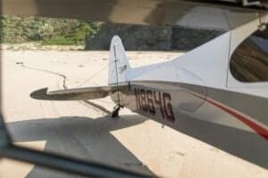 Tail section of N864G aircraft on a beach.