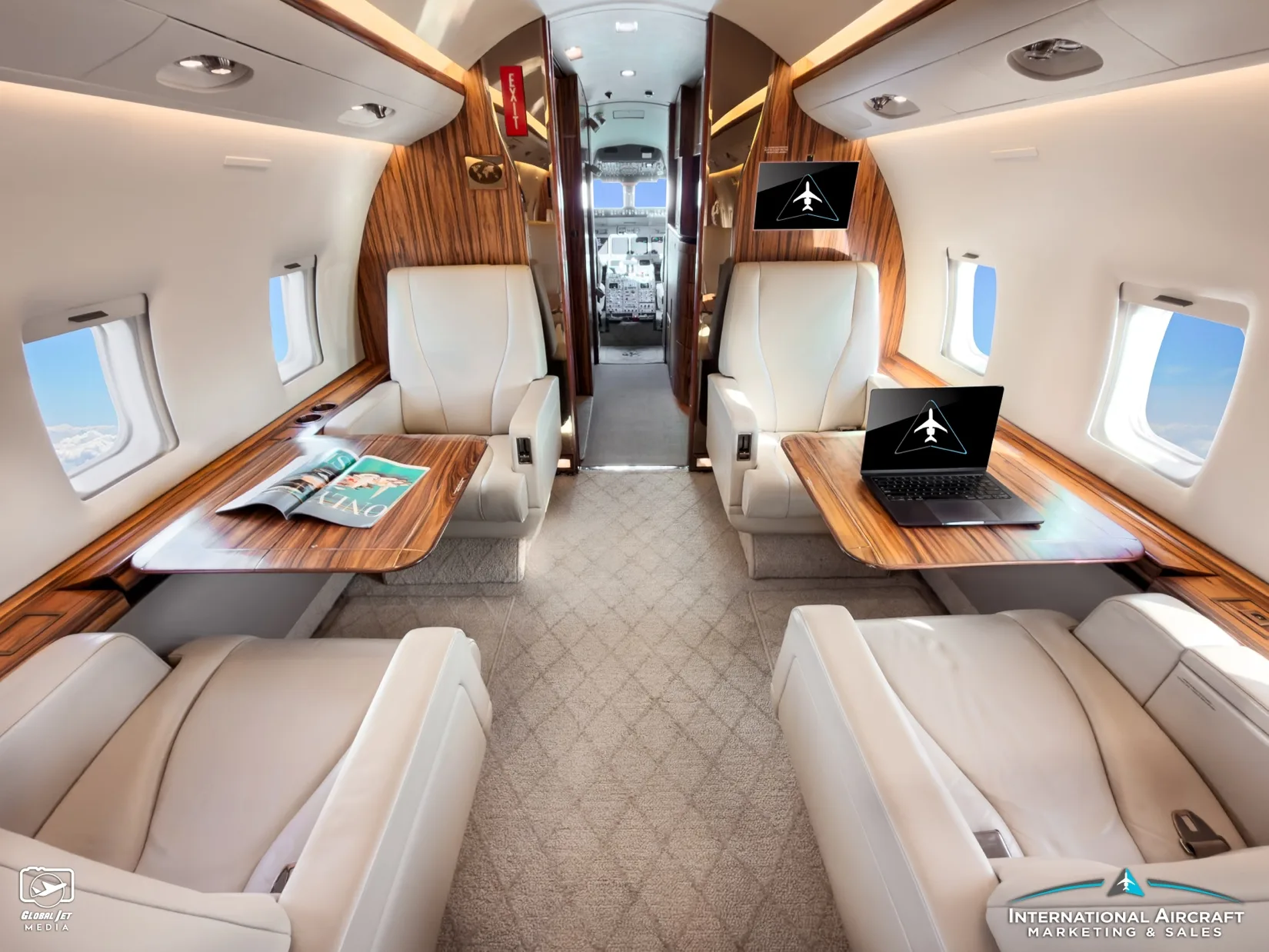 Cabin of the Bombardier Challenger with white leather seats and wood tables.