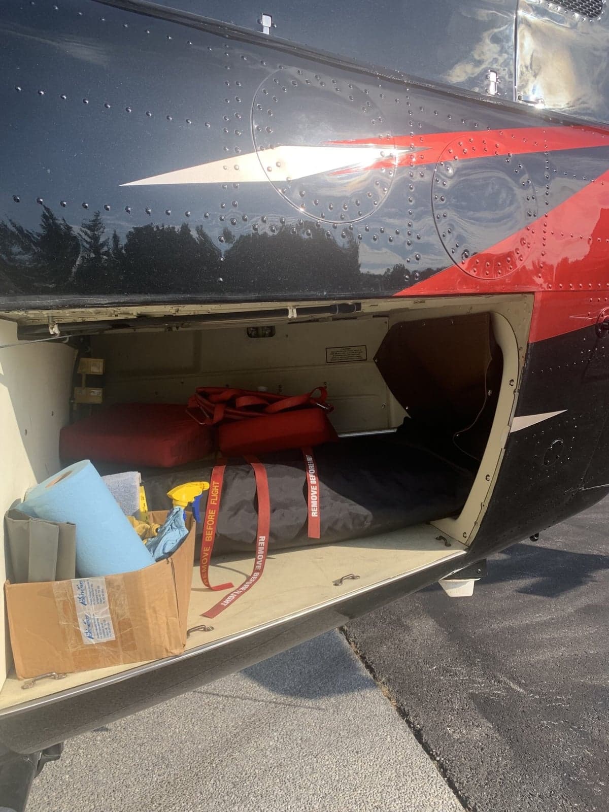 Open storage compartment on the Bell 407 helicopter with various items inside.