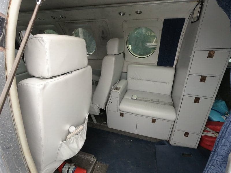 A view of the Beechcraft King Air 90C's cabin, showing the seating configuration and storage compartments.