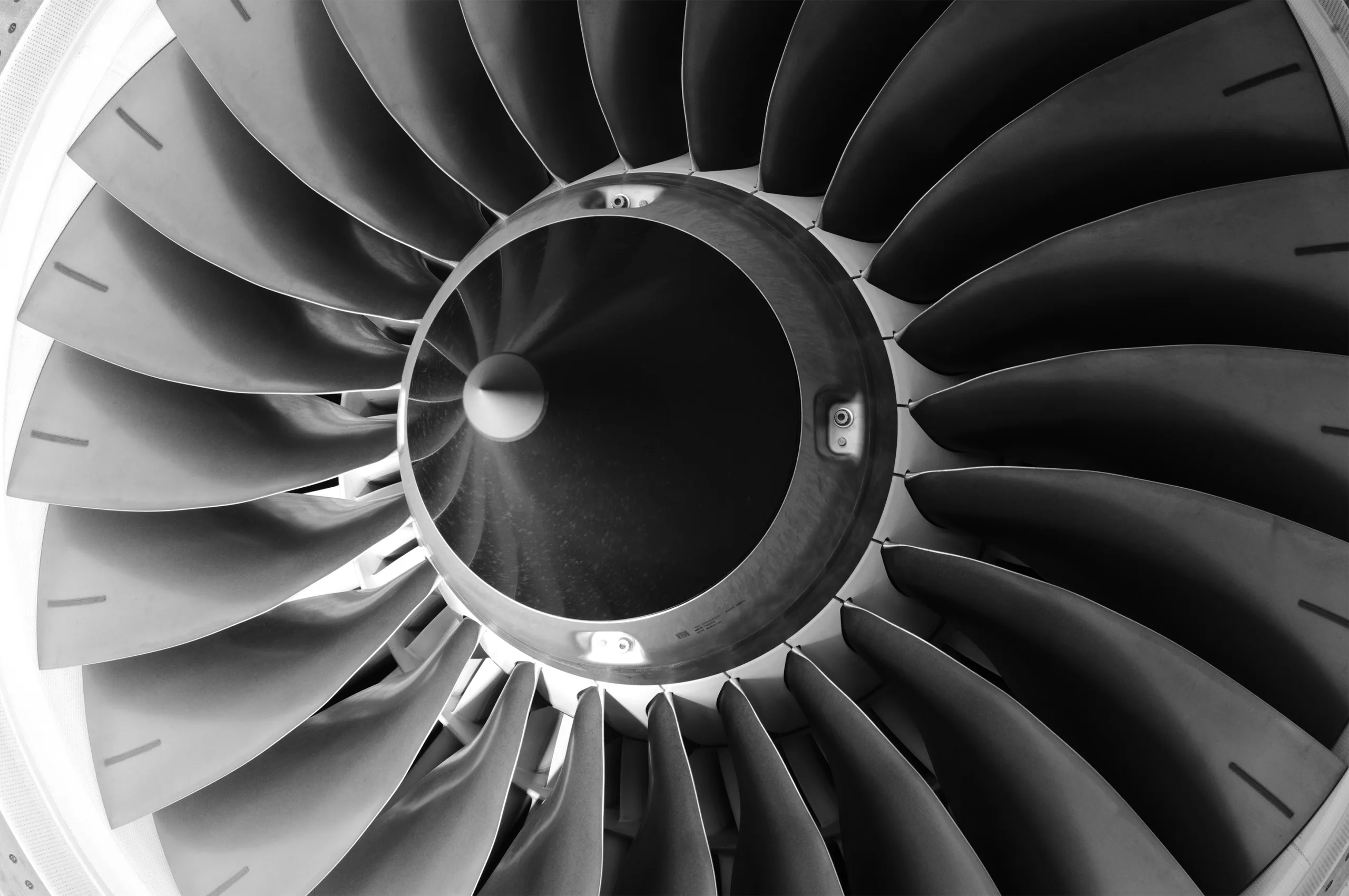 Close-up, black and white view of a jet engine's fan blades.