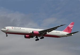 A Delta Boeing 767 in pink ribbon livery is on approach.