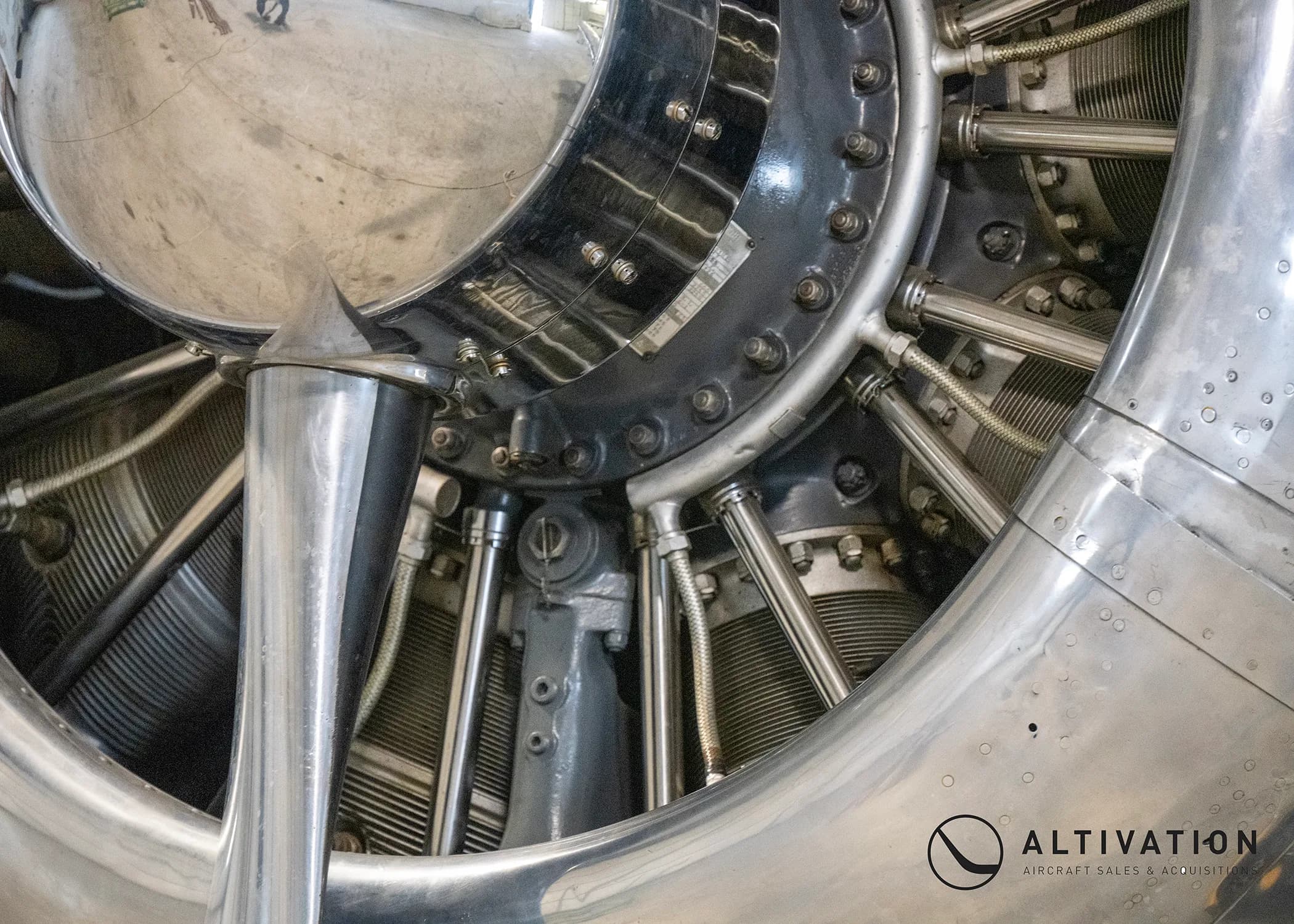 Close up of the propeller and engine of a silver aircraft.