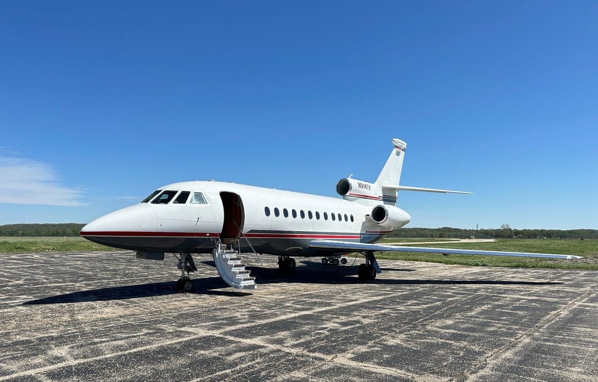 Side view of the N914TV aircraft parked on the tarmac with the entry stairs down.