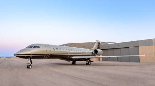 Gulfstream G450 on the tarmac with a white paint scheme and black accent stripes.