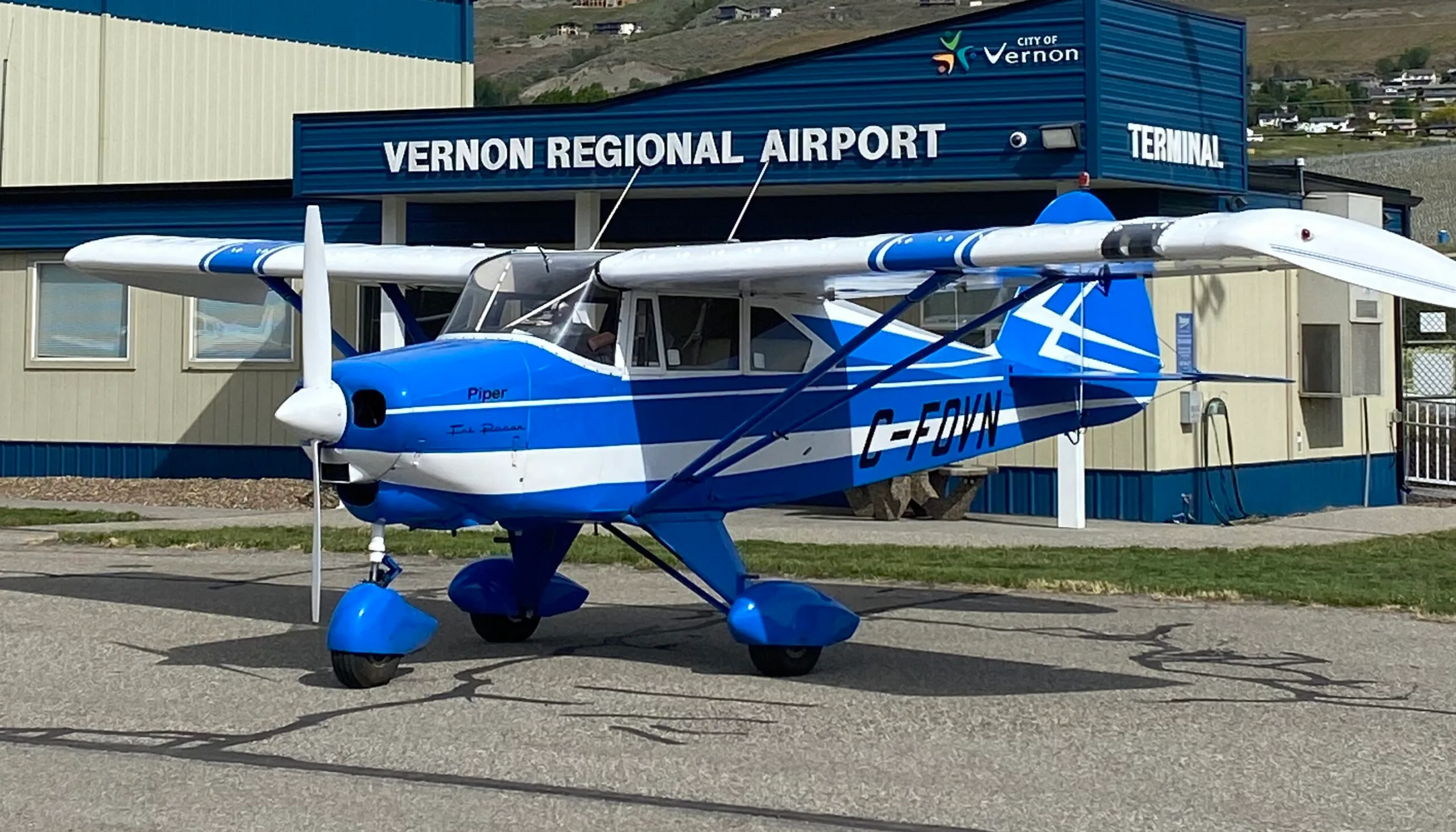 A blue and white Piper Tri-Pacer aircraft parked at Vernon Regional Airport.