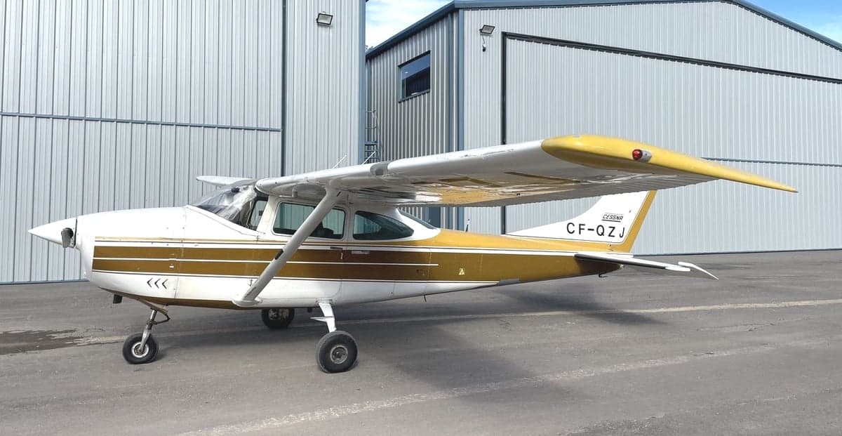 Cessna 182 Skylane parked in front of a hangar.