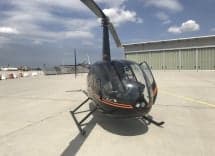 Front view of a Robinson R44 Raven II helicopter with the door open.