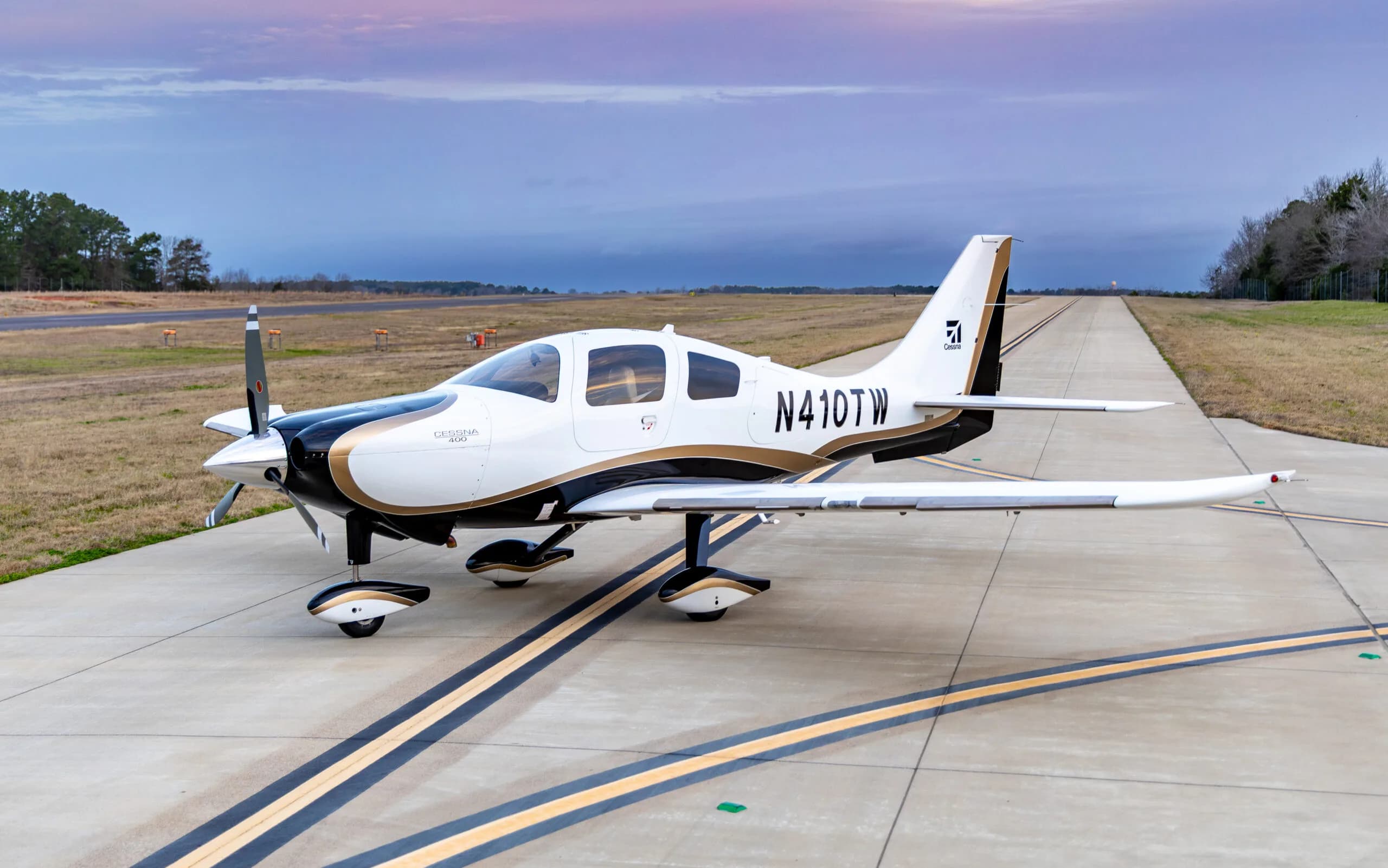 Cessna 400, registration N410TW, parked on the tarmac with a white and gold paint scheme.